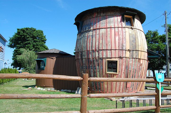 Unusual barrel-shaped house with faded red and brown exterior.