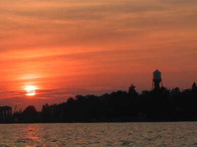 Pequaming town silhouette against a deep red and orange sunset.