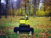 Iron County roadside park sign marks Michigan’s first picnic site amid autumn forest landscape.