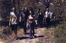  Group of people walking along wooded Apple Blossom Trail, once a historic iron ore rail corridor.