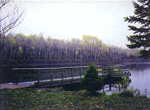 Wooden fishing dock on tranquil Fortune Pond, a former iron mine now reclaimed by nature.