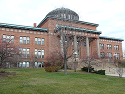 Red sandstone courthouse with a domed roof and tall columned entrance.