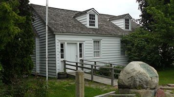 White clapboard house on Water Street, part of historic district in Sault Ste. Marie, Michigan.