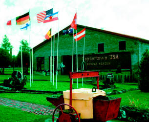  Coppertown USA Mining Museum with mining cart, flags, and exhibits on Copper Country heritage.