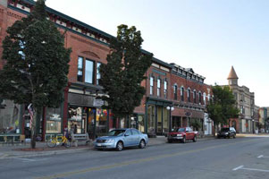Historic downtown Menominee with late 19th-century brick buildings and tree-lined Main Street.
