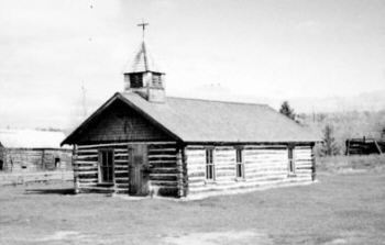 Restored 1890s log Pioneer Church near Mansfield mine site, memorializing lost miners and community.