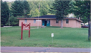 Small brick building housing the Rockland Historical Museum, with red sign and flagpole out front.